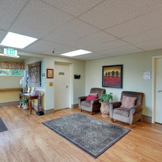 A cozy waiting area featuring comfortable seating and decorative elements, illuminated by natural light.