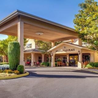 A welcoming entrance to a building with a large covered driveway and well-maintained landscaping.