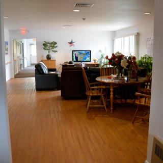 A cozy living room with sofas, a television, and a wooden dining table.