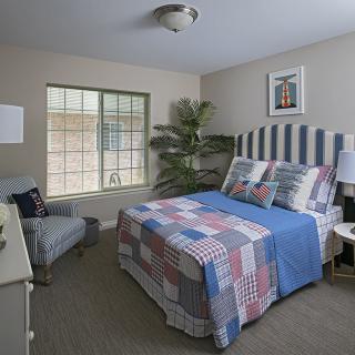 Cozy bedroom with a striped headboard and quilt.