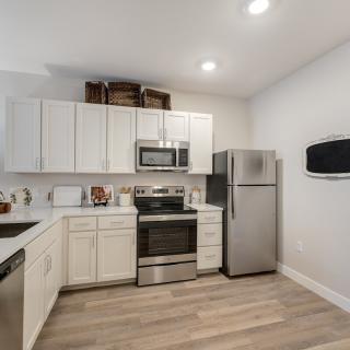 A modern kitchen with white cabinets and stainless steel appliances.