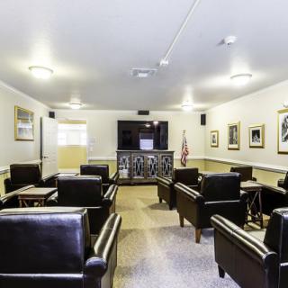 A meeting room with leather chairs and a projector screen.