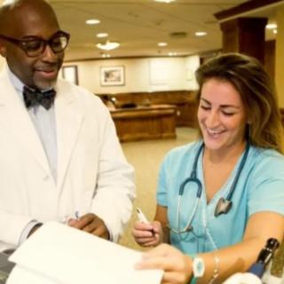 A doctor and a nurse discussing patient charts in a hospital setting.