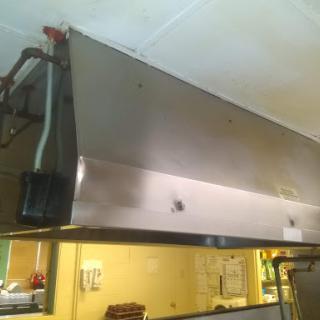 A stainless steel exhaust hood installed in a commercial kitchen.