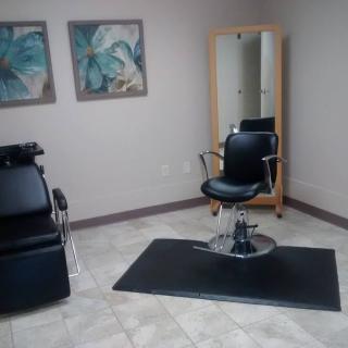 A clean and modern hair salon station with a styling chair and mirror.