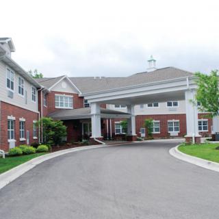 The front entrance of a large brick building with a covered driveway.