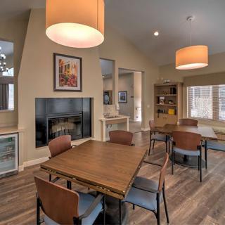 A modern dining area featuring wooden furniture, pendant lights, and a cozy fireplace.