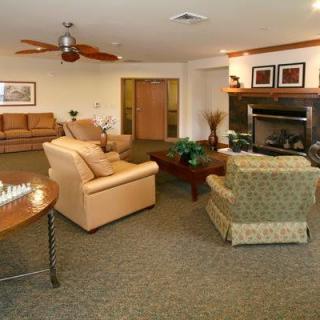 A cozy living room featuring comfortable seating, a central table, and a warm fireplace.