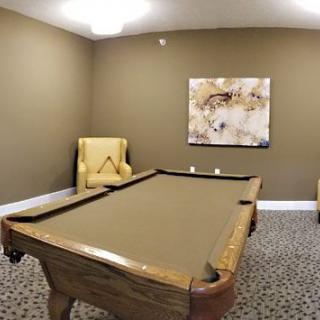 A cozy game room featuring a pool table and comfortable seating.