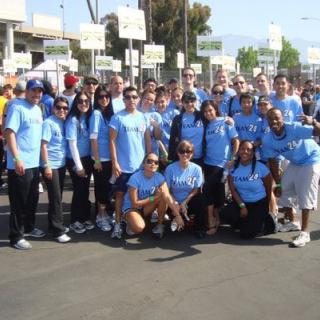 A group of people wearing blue shirts gathered outdoors for an event.