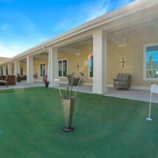 A luxurious patio overlooking a well-manicured lawn with an outdoor seating area and a small golf practice setup.