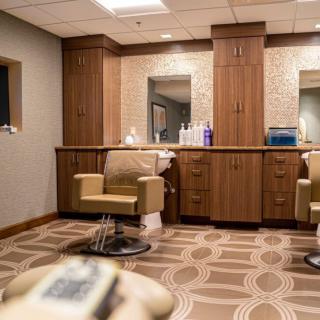 A modern barber shop interior with stylish chairs and mirrors.