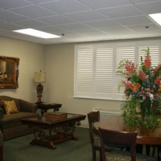 A cozy waiting room with comfortable seating and floral arrangements.