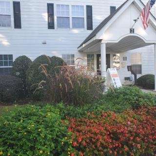 A charming house with well-maintained landscaping and vibrant flowers in the front yard.