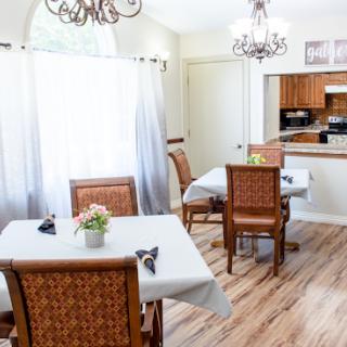 A well-designed dining room featuring wooden chairs, elegant chandeliers, and a cozy atmosphere.