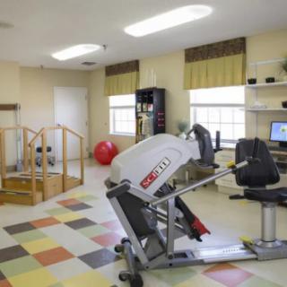 A rehabilitation room equipped with exercise machines and therapy tools.