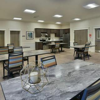A modern kitchen and dining area with neatly arranged tables and chairs.