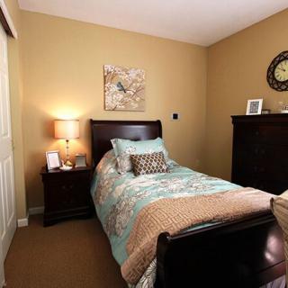 A cozy bedroom with a single bed, warm lighting, and decorative elements.