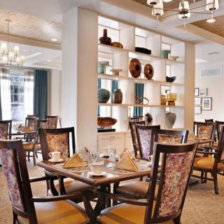 An elegantly designed dining room with decorative shelves and stylish lighting.