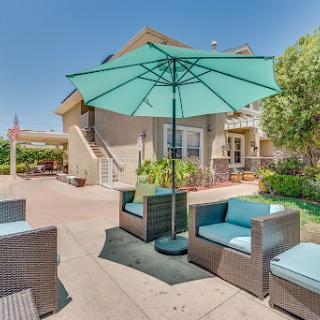 A cozy outdoor patio setup with comfortable seating and an umbrella for shade.
