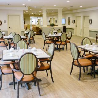 A spacious and well-lit dining area with neatly arranged tables and chairs.