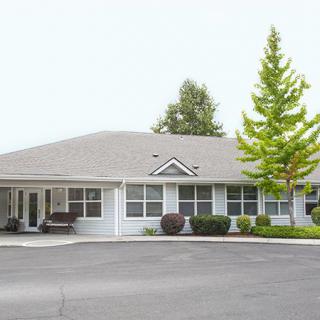 A suburban residential building surrounded by trees.