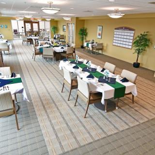 A well-organized dining area with neatly arranged tables and chairs, featuring tablecloths and tasteful decor.