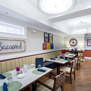 An inviting restaurant dining area with neatly arranged tables and colorful artwork on the walls.