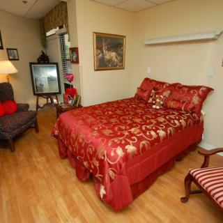 Cozy bedroom with elegant red bedding and classic furniture.