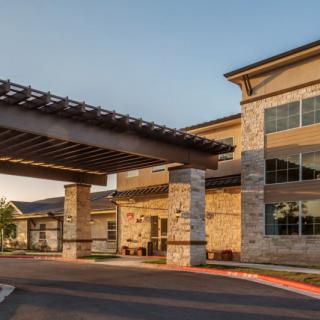 A modern commercial building with a stone entrance and covered walkway.
