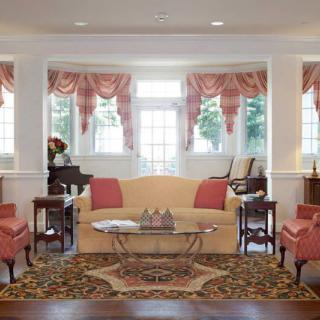 Elegant living room with classic decor and large windows.