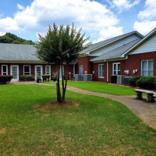 A view of a building complex with green lawns and a central pathway.