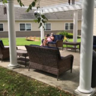 People relaxing on a patio under a pergola.