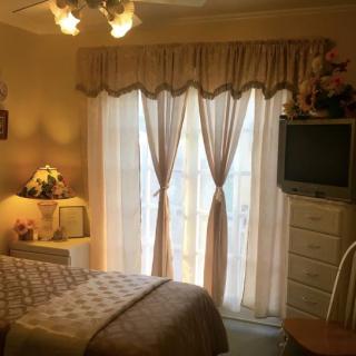 Cozy bedroom interior with elegant curtains and classic furnishings.