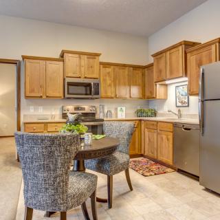 A modern kitchen with wooden cabinets and a cozy dining area.