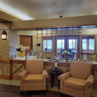 A cozy lounge area featuring patterned chairs and a bright window view.