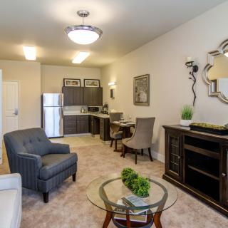 A modern apartment living room with an open kitchen, featuring stylish furniture and elegant decor.