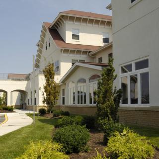 A modern building with well-maintained landscaping and large windows.