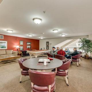 A cozy indoor lounge with seating areas and people socializing.
