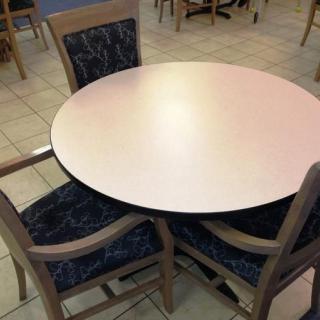 A round table with four chairs in a cafe setting.
