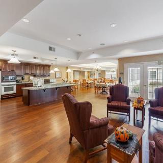 A spacious and modern open-concept kitchen and living area with wood flooring and comfortable seating.