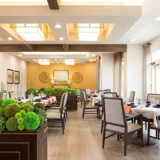 An elegant restaurant dining area with modern decor, featuring neatly arranged tables and chairs.