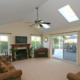 A spacious living room with a fireplace, television, and sliding glass doors leading to a patio.
