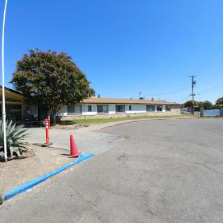 A view of a building from the parking lot under a clear blue sky.