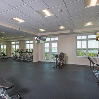 A spacious gym with exercise equipment and large windows.