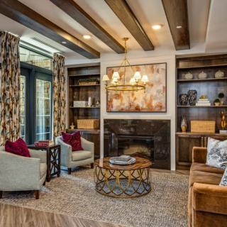 A cozy living room with a fireplace, featuring warm colors and stylish decor.