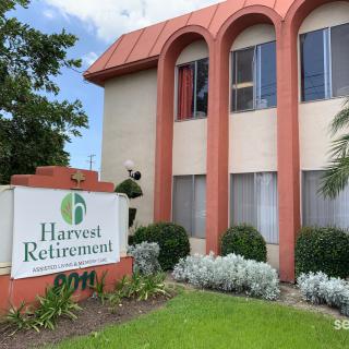 A retirement home with a prominent sign and well-maintained landscaping.