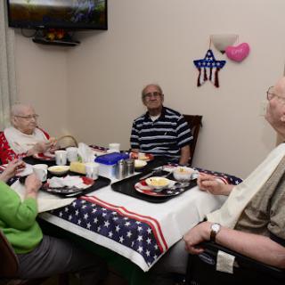 A group of seniors enjoying a meal together in a cozy dining area.