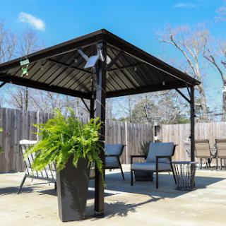A stylish outdoor gazebo with comfortable seating, perfect for enjoying the sunny weather.