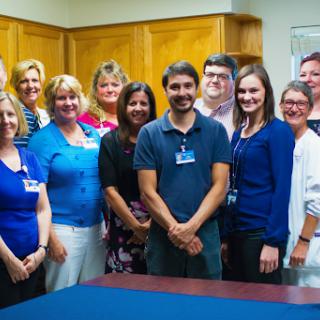 A team of professionals posing together in an office setting.